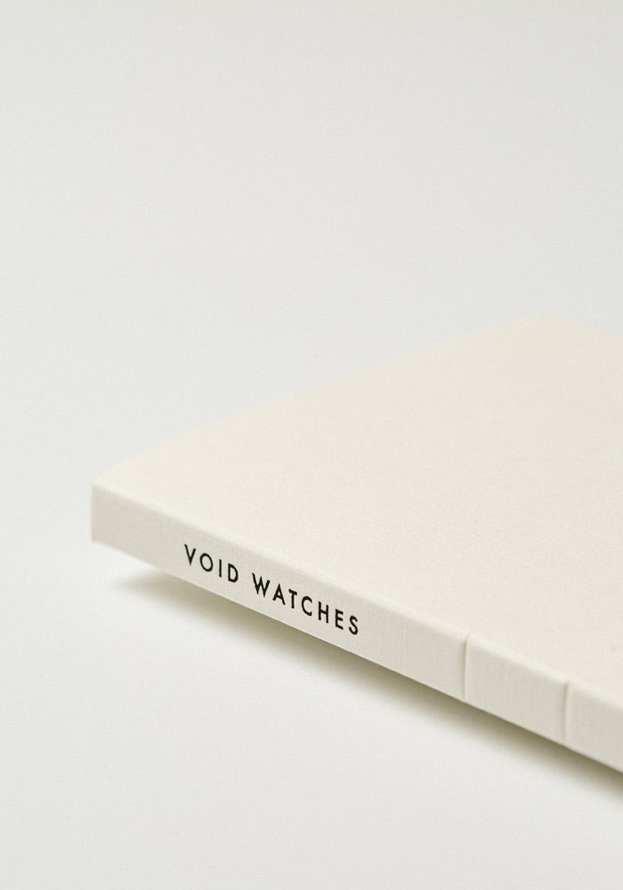 VOID Watches's off-white strap packaging featuring their black strap with a brushed steel buckle.